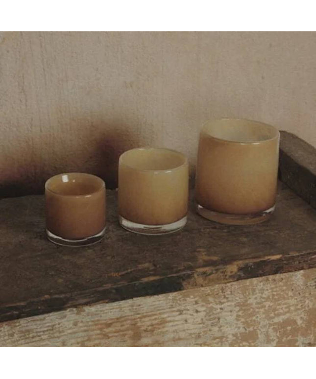 Glasfyrfadslys i mørk sand